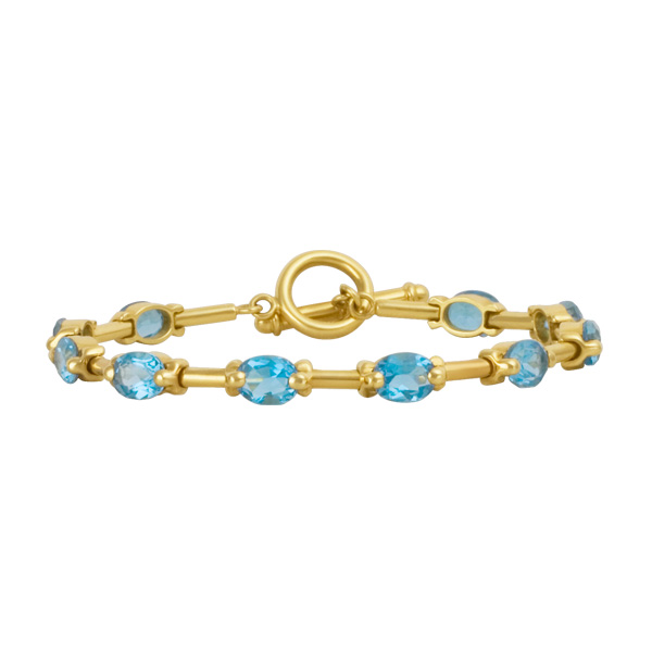 Bright toggle oval cut blue topaz bracelet in 18k with
